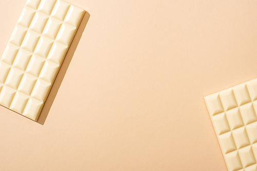 top view of delicious white chocolate bars on beige background
