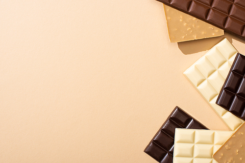 top view of delicious chocolate bars isolated on beige