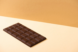 sweet delicious dark chocolate bar on beige background