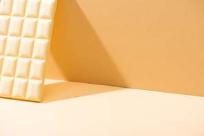 delicious white chocolate bar on beige background