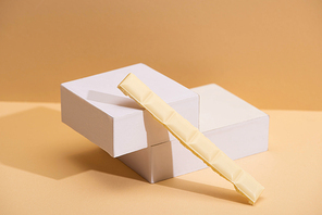 delicious white chocolate piece and cubes on beige background