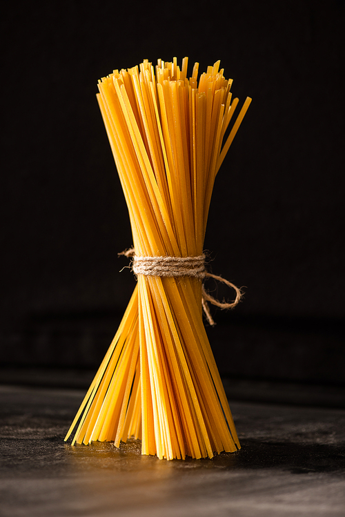 tied uncooked Italian spaghetti isolated on black