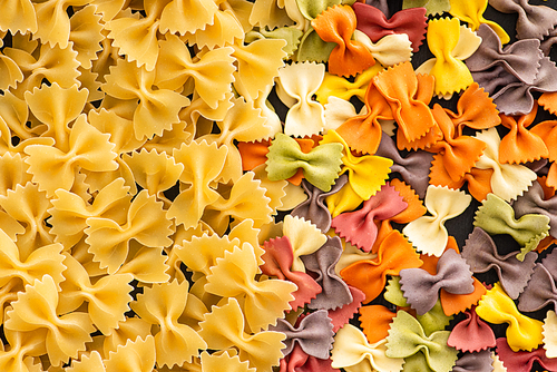 top view of raw colorful fusilli and farfalle pasta