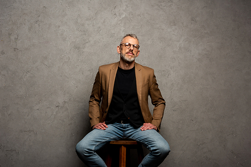 bearded businessman in glasses  and sitting on grey
