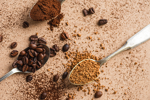 top view of ground, instant coffee and beans in spoons on beige surface