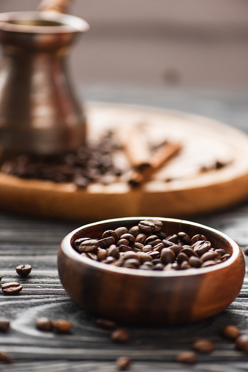 selective focus of bowl with coffee beans on wooden surface