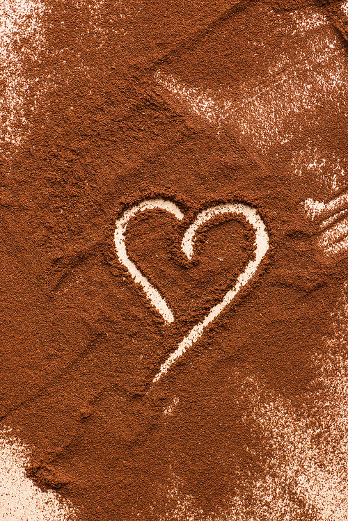 top view of heart drawn on ground coffee