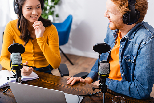 selective focus of asian radio host talking to colleague in radio studio