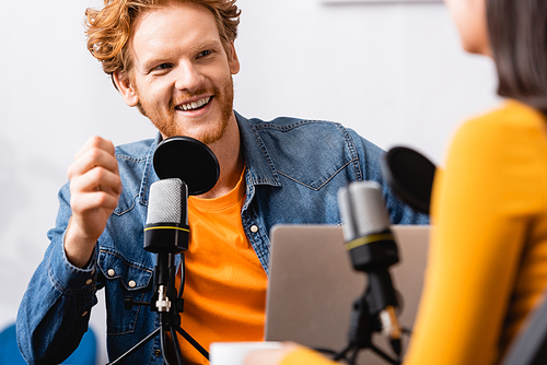 selective focus of excited radio host interviewing woman in radio studio