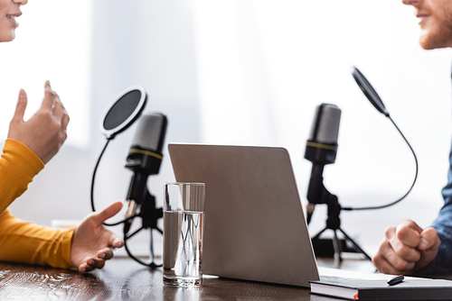 cropped view of woman gesturing while talking to interviewer in radio studio