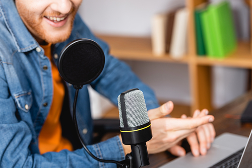 cropped view of excited announcer gesturing while speaking in microphone at workplace