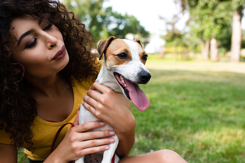 Selective focus of young woman looking at jack russell terrier dog