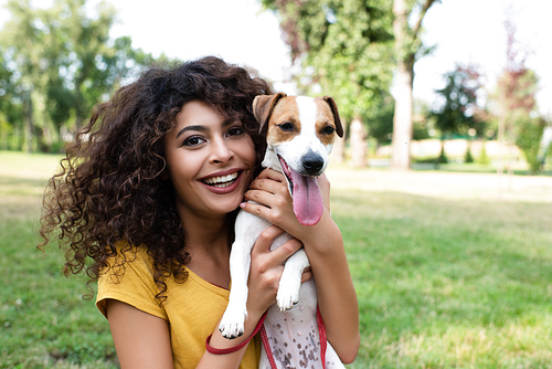 Selective focus of young woman holding dog and 