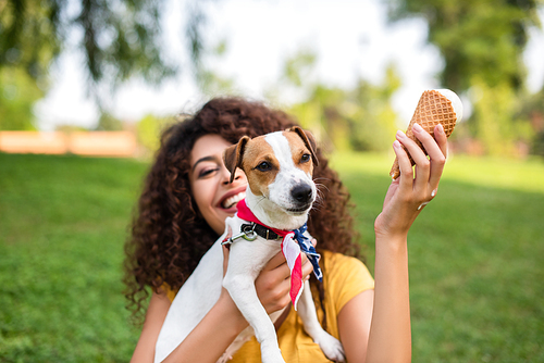 Selective focus of young woman holding ice cream and jack russell terrier dog