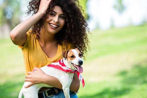 excited woman touching hair and  while holding jack russell terrier dog