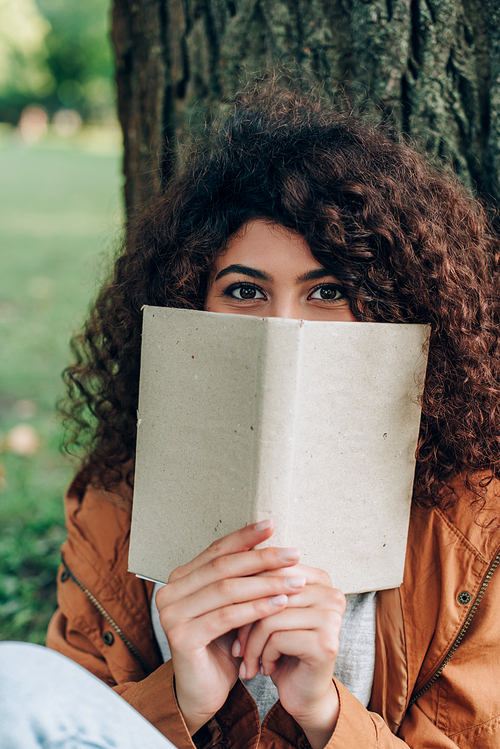 Selective focus of woman  while holding book in park