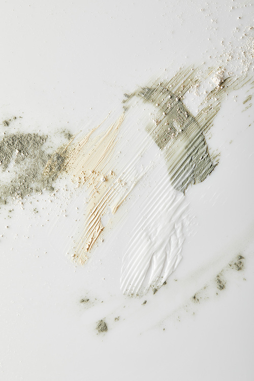Top view of clay powder, cosmetic and tone cream brushstrokes on grey background