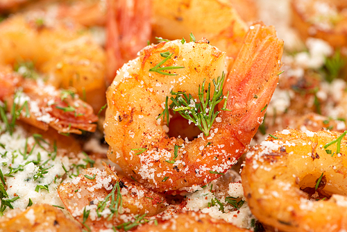 close up view of fried shrimps with dill and grated cheese
