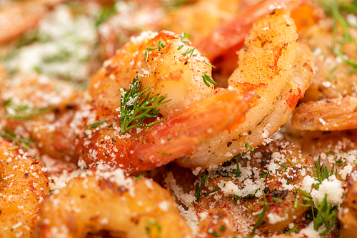 close up view of fried shrimps with dill and grated cheese