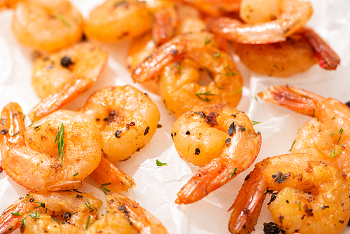 close up view of fried shrimps on white parchment paper