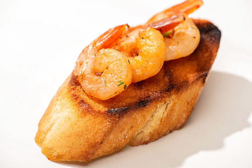 close up view of canape with toast bread and fried shrimps on white background