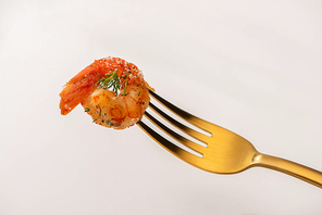 fried shrimps on parchment paper with sauce and lime near golden cutlery on white background
