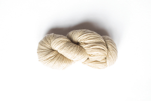 top view of beige yarn on white background with copy space