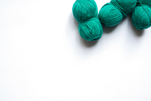 top view of green wool yarn on white background with copy space