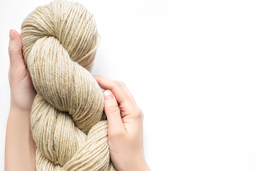 cropped view of woman holding beige yarn on white background with copy space
