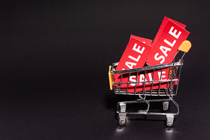 toy cart with sale tags on dark background, black friday concept
