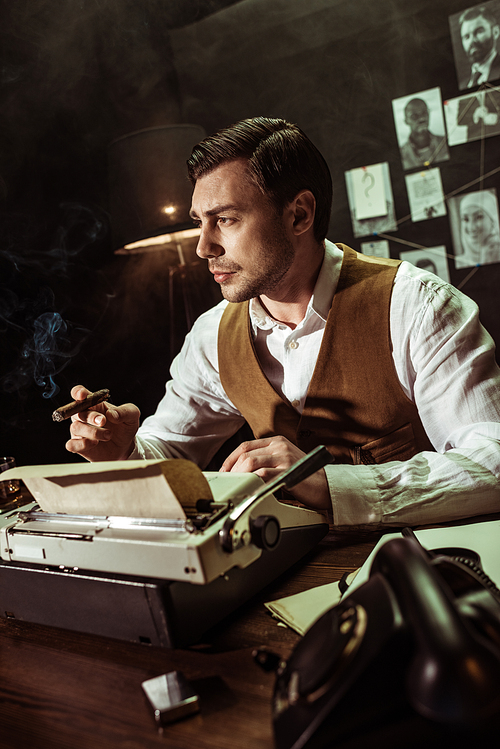 Detective holding cigar while using typewriter in dark office