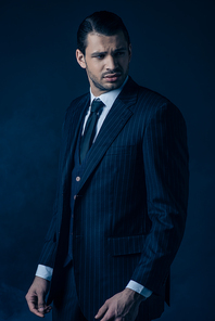 Confused gangster looking away on dark blue background
