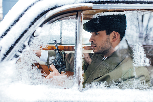 Selective focus of dangerous gangster with gun driving car