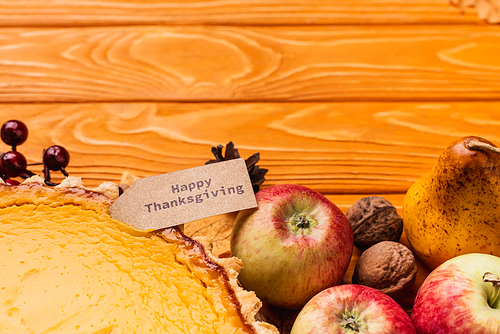 top view of thanksgiving pumpkin pie with al decoration on wooden background