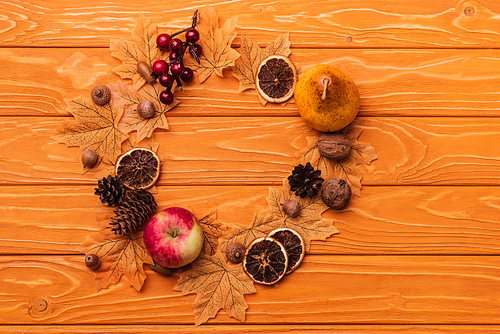 top view of round frame with autumnal decoration on wooden background