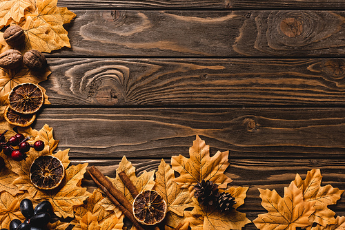 top view of autumnal decoration and foliage on brown wooden background