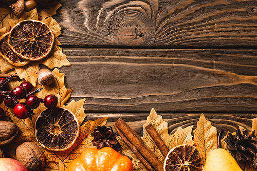 top view of autumnal harvest and decoration on brown wooden background