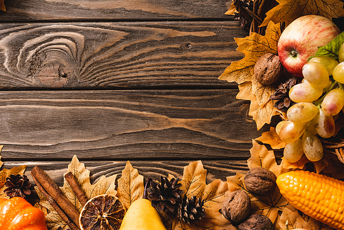 top view of autumnal harvest and decoration on brown wooden background