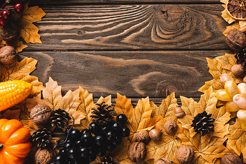 top view of autumnal harvest and foliage on brown wooden background