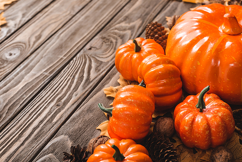 autumnal decoration and pumpkins on brown wooden background