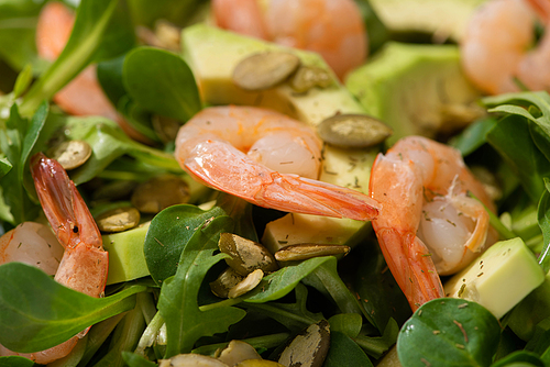close up view of fresh green salad with pumpkin seeds, shrimps and avocado