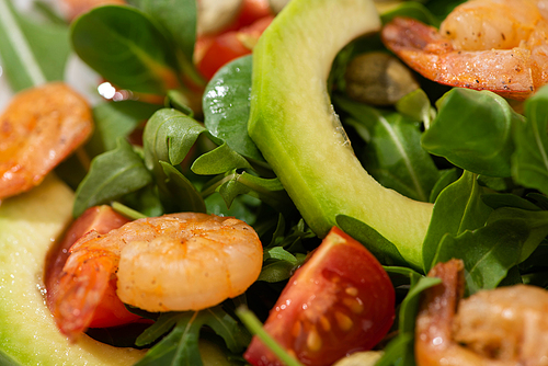 close up view of fresh green salad with cherry tomatoes, shrimps and avocado