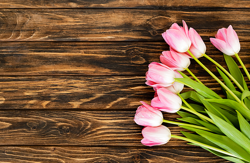 top view of blooming tulips on wooden surface, mothers day concept