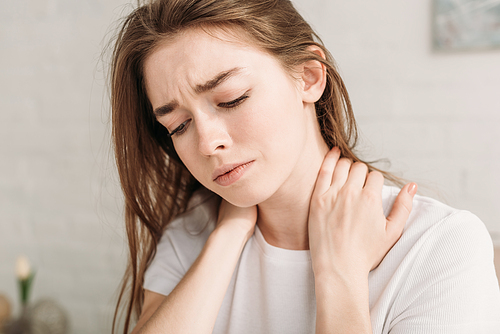 upset girl touching neck while suffering from pain