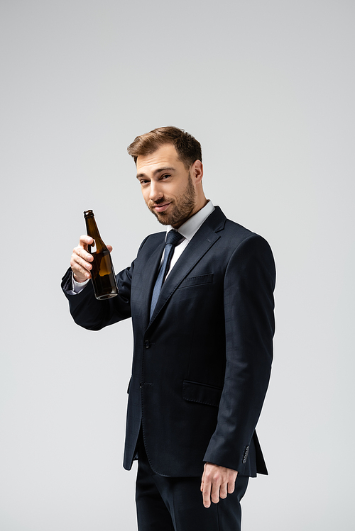 handsome businessman in suit with beer isolated on grey