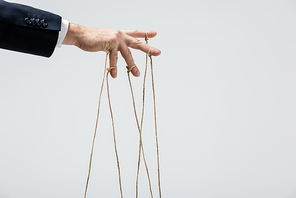 partial view of puppeteer with strings on fingers isolated on grey