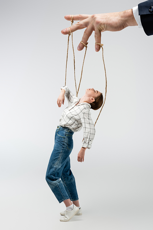 cropped view of puppeteer holding marionette on strings isolated on grey