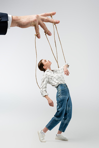 cropped view of puppeteer holding marionette on strings isolated on grey