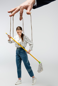 cropped view of puppeteer holding marionette on strings isolated on grey