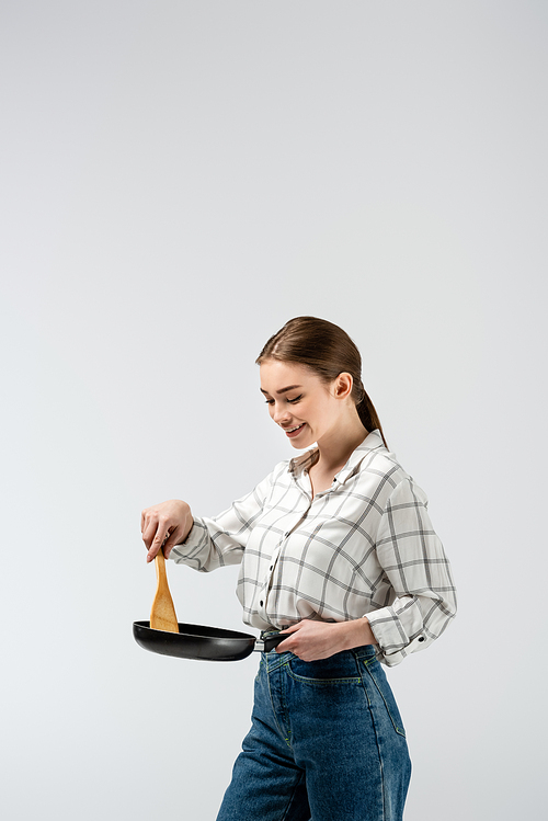 attractive girl posing like puppet with mop and frying pan isolated on grey